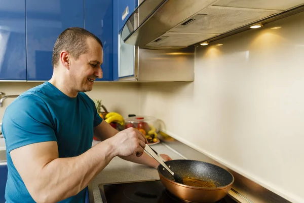 Homme ajoutant des ingrédients au sucre caramélisé dans un wok — Photo