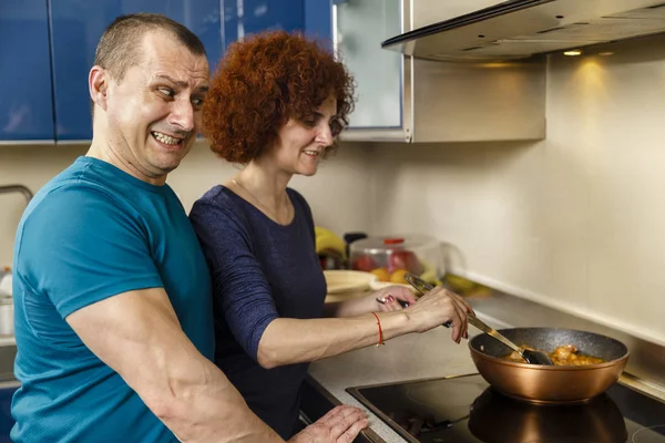 Boldog pár otthon, a tűzhelyen serpenyőben a főzés — Stock Fotó