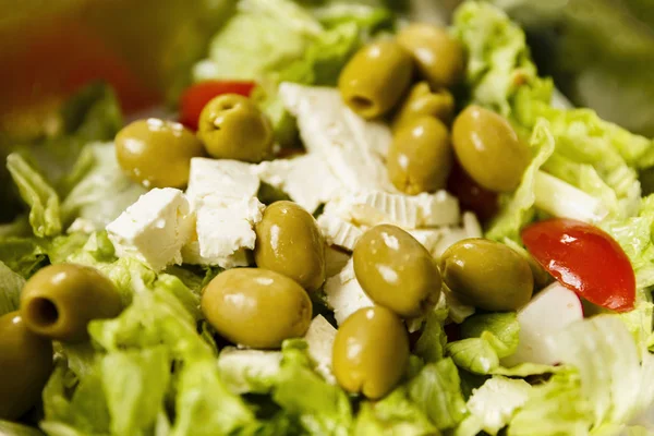 Greek salad with iceberg lettuce, olives, feta cheese and condim
