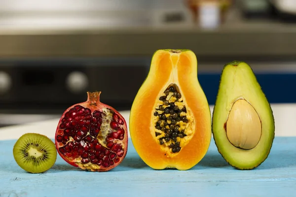 Variety of exotic fruits halved, over blurred background — Stock Photo, Image