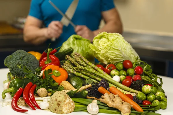 Mann mit einer großen Auswahl an Gemüse, bereit zum Kochen — Stockfoto