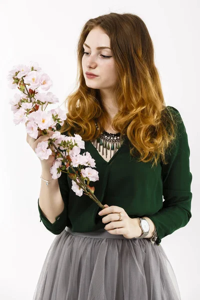 Retrato de una hermosa mujer pelirroja sosteniendo una flor en su —  Fotos de Stock