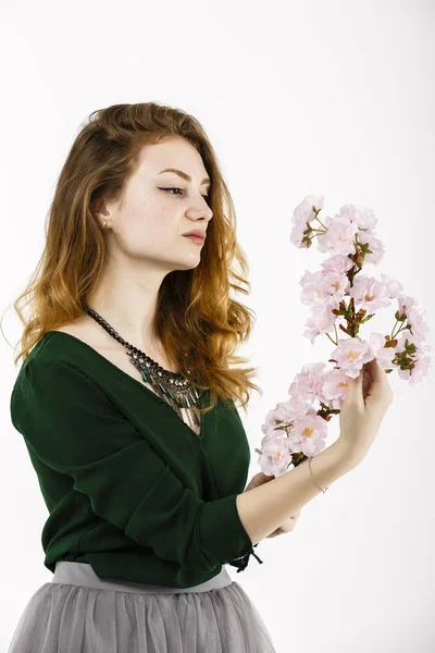 Retrato de una hermosa mujer pelirroja sosteniendo una flor en su — Foto de Stock