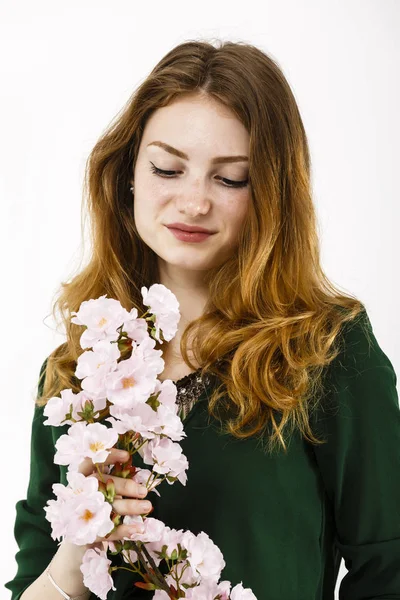 Портрет красивої рудої жінки, що тримає в руках квітку — стокове фото