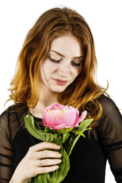 Portrait d'une belle femme aux cheveux roux tenant une fleur dans son — Photo