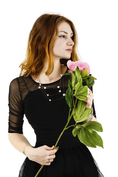 Retrato de una hermosa mujer pelirroja sosteniendo una flor en su — Foto de Stock