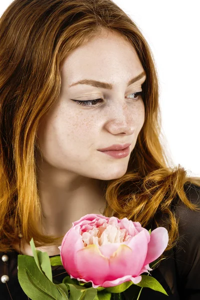 Retrato de una hermosa mujer pelirroja sosteniendo una flor en su —  Fotos de Stock