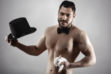 A muscular man with a rabbit in his hand clipart