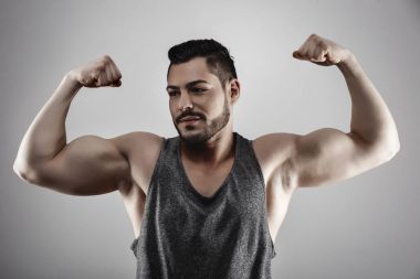 Yakışıklı kaslı adam stüdyoda poz veriyor.
