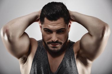 Yakışıklı kaslı adam stüdyoda poz veriyor.