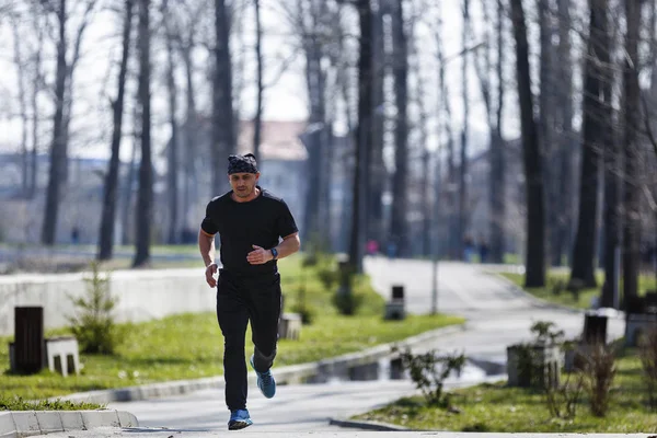 Un hombre de mediana edad corriendo por el parque — Foto de Stock