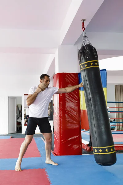 Μαχητής Kickbox κατάρτισης σε ένα γυμναστήριο με σακούλες διάτρησης, δείτε το σύνολο — Φωτογραφία Αρχείου