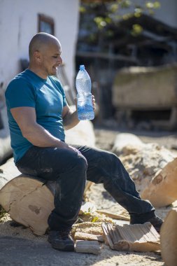 Susamış oduncu su içiyor ve mola veriyor.