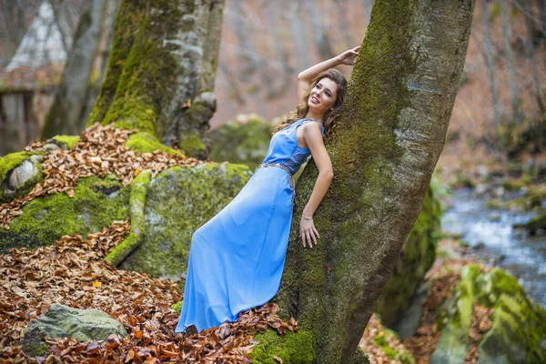 Mulher em vestido azul perto de um rio no dia de outono — Fotografia de Stock