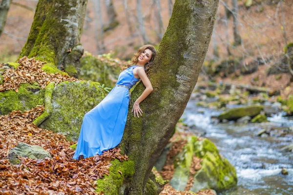 Mulher em vestido azul perto de um rio no dia de outono — Fotografia de Stock
