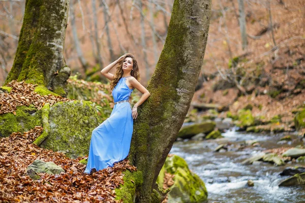 Frau in blauem Kleid in der Nähe eines Flusses an einem Herbsttag — Stockfoto