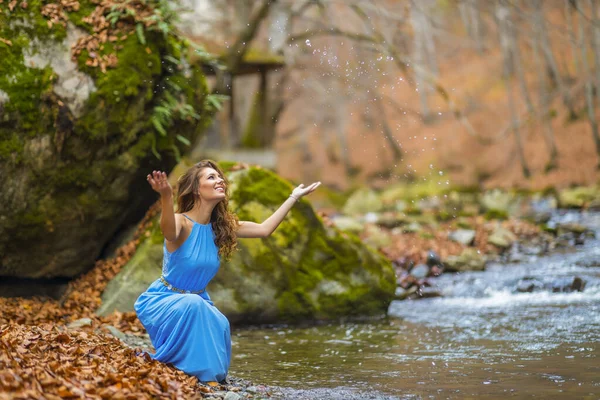 Mujer en vestido azul cerca de un río en el día de otoño — Foto de Stock