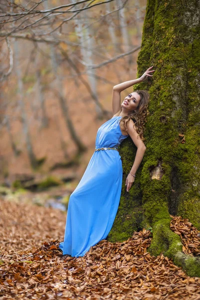 Hermosa mujer en vestido azul en el bosque en el día de otoño — Foto de Stock