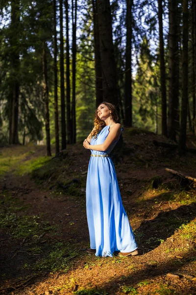 秋の日に森の中で青いドレスの美しい女性 — ストック写真