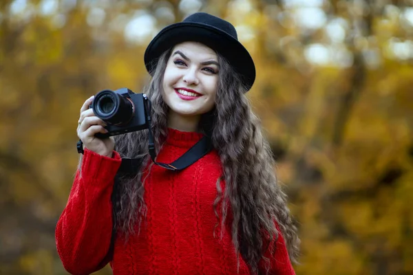 Mulher bonita com câmera fotográfica moderna no parque de outono — Fotografia de Stock