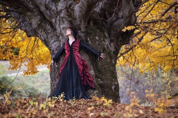 Portrait of a mature lady in a vintage dress, autumn time.