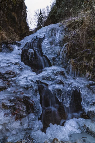 Una pequeña cascada activa. Limpio arroyo de montaña, nieve invierno la — Foto de Stock