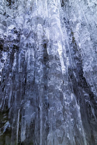 Gyönyörű alakú jégcsapok egy hegyen egy fagyott vízesésből. — Stock Fotó
