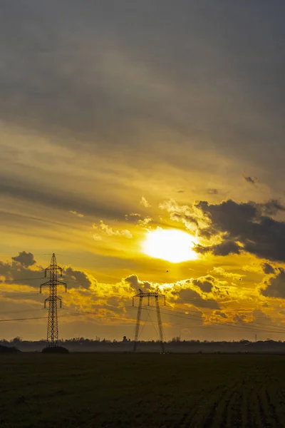 Céu ao pôr-do-sol com nuvens escuras e sol atrás — Fotografia de Stock