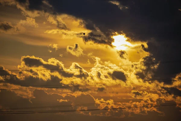 Sky at sunset with dark clouds and sun behind — Stock Photo, Image