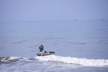 Da Nang, Vietnam, 16 Ocak 2020, Vietnamlı balıkçı denizdeki yuvarlak bambu ağacının içinde uçuyor..