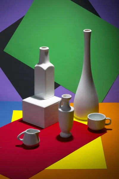 Stillleben mit Vasen und Tassen auf farbigem Hintergrund — Stockfoto
