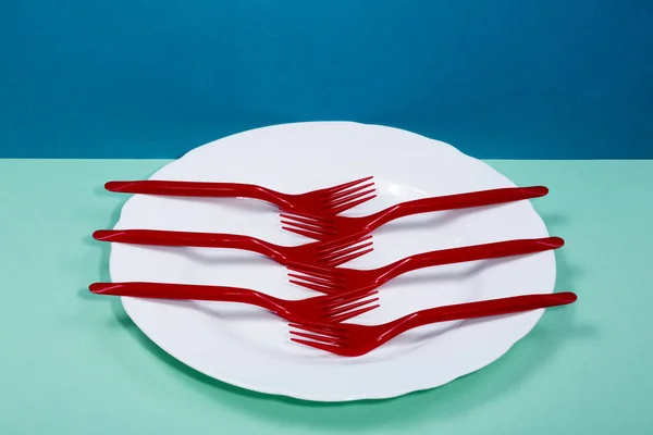 Műanyag villás és egy tányér színes háttéren csendélet — Stock Fotó