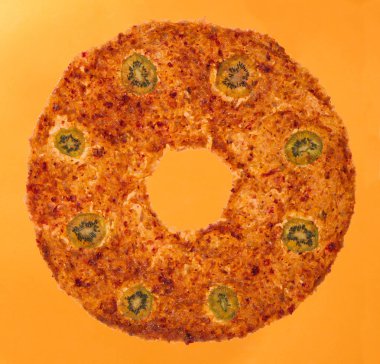 Tatlı meyve pastel turuncu bir arka plan üzerinde kivi dilimleri ile yuvarlak şeklinde