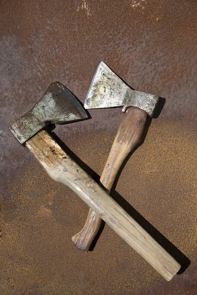 Two old axes on a rusty metal sheet — Stock Photo, Image