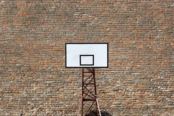 Escudo de basquete em um campo de esportes em um fundo de parede de tijolo — Fotografia de Stock