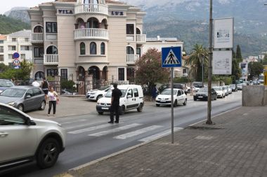 Polis memuru trafik yaya geçidi üzerinde yönlendirir. Budva, Karadağ.