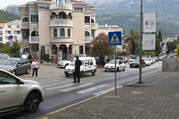 Polis memuru trafik yaya geçidi üzerinde yönlendirir. Budva, Karadağ.