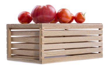Beyaz bir arka plan üzerindeki ahşap kutusunda olgun domates.