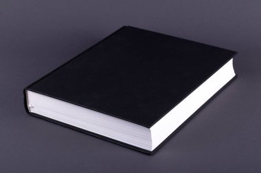 Karanlık bir arka plan üzerinde büyük bir siyah kitap