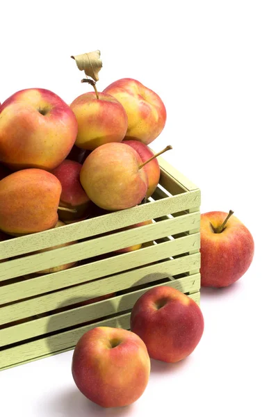 Fragmento de uma caixa com maçãs maduras em um fundo branco — Fotografia de Stock