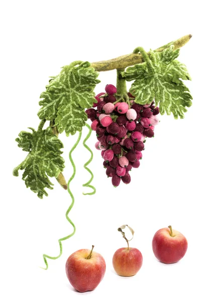 A bunch of grapes from felted wool next to apples on a white background — Stock Photo, Image