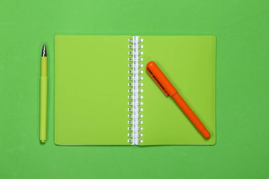 Yeşil defter ve renk arka plan üzerinde iki kalem