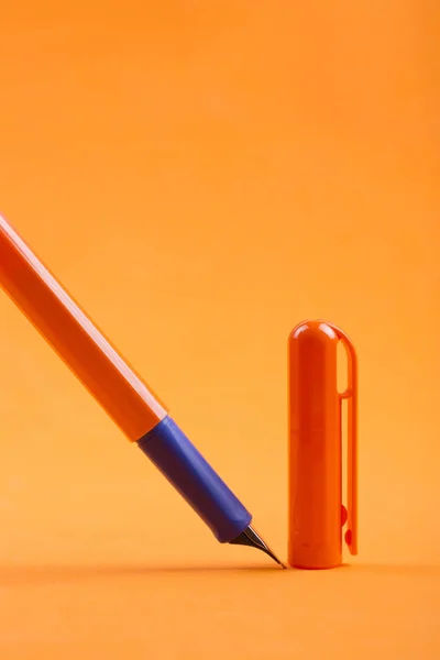 オレンジ色の背景にキャップ万年筆 — ストック写真