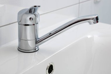 Lavabonun üzerinde yüklü bir modern banyo musluk yakın çekim