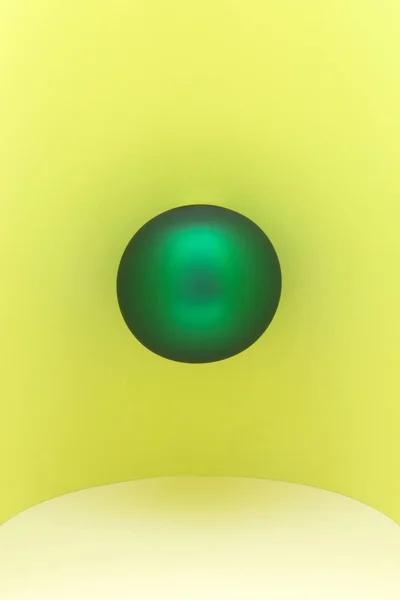 Abstract still life with a green Christmas tree on a yellow background