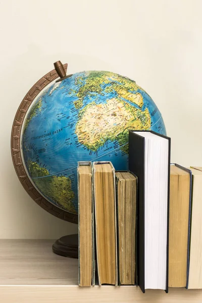 Geographic globe and books on the table