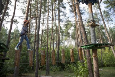 Çocuk ip parkta bir bölümü üzerinden geçer