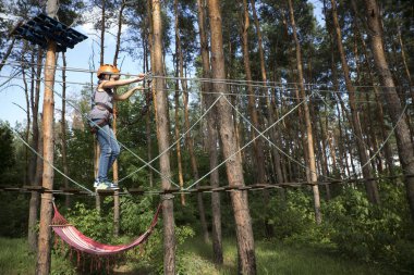 Çocuk ip parkta bir bölümü üzerinden geçer