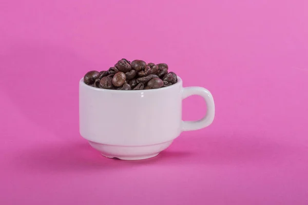 Белая Чашка Кофейными Зёрнами Розовом Фоне — стоковое фото