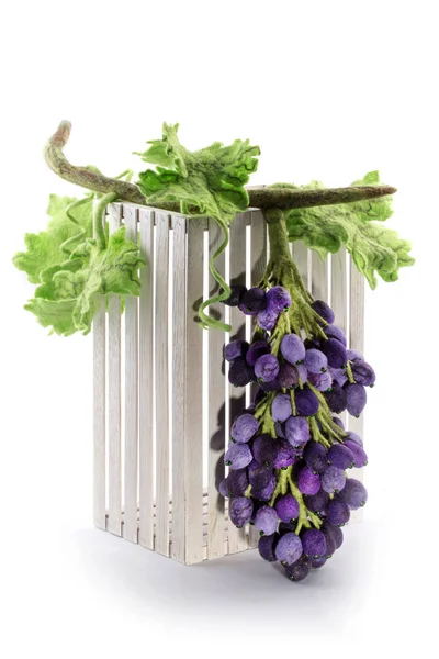 Um monte de uvas artesanais de lã feltrada em uma caixa de madeira — Fotografia de Stock